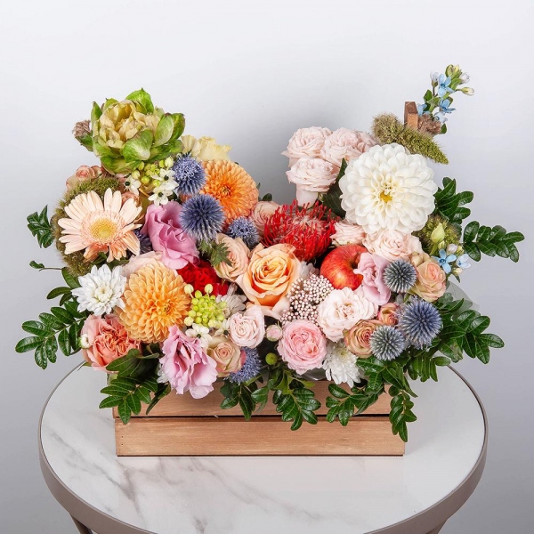Orange Dahlia - 3, Rose Veggie 50 cm - 1, Peony sprayrose - 2, Spray rose: white, cream, light pink 50 cm - 1, Pink Lisianthus (Eustoma) - 2, Gerbera white - 5, Pink-orange rose Phoenix 50 cm - 2, Wooden pot, Oasis, Pistachio, Ozotamnus, Ornithogalum, Oksipetalum, Eryngium, Veronica spray, Celosia, Nutan, Apple, 1 pc.
