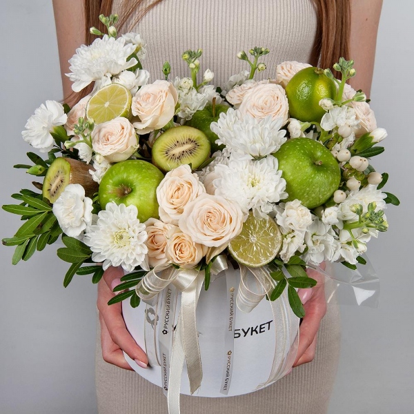 Baltica White Spray Chrysanthemum - 3, Peony sprayrose - 3, White Matthiola - 2, White spray carnation - 3, Round flower box medium, Oasis, Pistachio, Hypericum, Apple, 1 pc., Kiwi, Lemon, 1 pc., Wrapping Paper