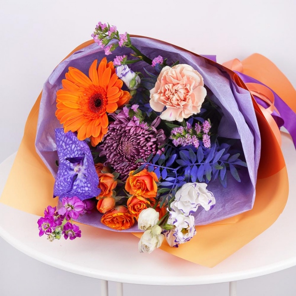 Chrysanthemum Bigoudi purple - 1, Spray rose: yellow, orange 50 cm - 2, Carnation white, cream - 2, Matthiola Lilac - 1, Gerbera daisies - 1, Vanda Orchid bud - 1, Purple Lisianthus (Eustoma) - 2, Flask for orchids, Pistachio, Wrapping Paper, Pink Statice
