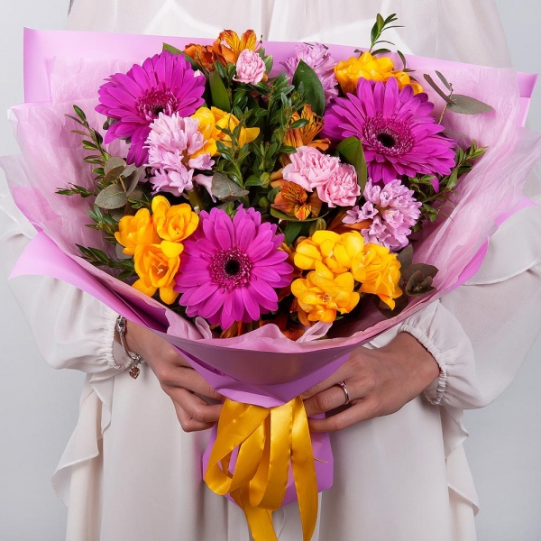 Purple gerbera - 3, Pink Hyacinth - 3, Alstromeria Yellow, Orange - 4, Pink spray carnation - 4, Freesia - 4, Pistachio, Eucalyptus, Wrapping Paper
